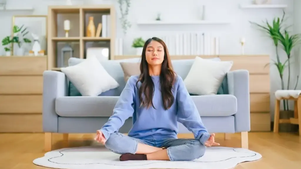 Person meditating with soft expression — alt: Person learning how to meditate and relax with a calm focused practice